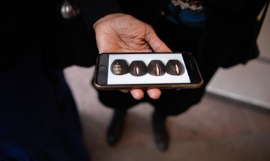 En kvinna håller i en telefon som visar en bild på de fyra olika formerna av könsstympning (1)