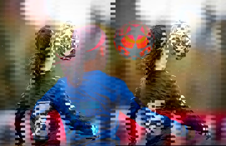 Ung kvinna bakifrån som spelar fotboll