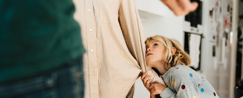 Två vuxna står mitt emot varandra. Ett barn drar i den ena vuxnas arm och tittar oroligt uppåt.