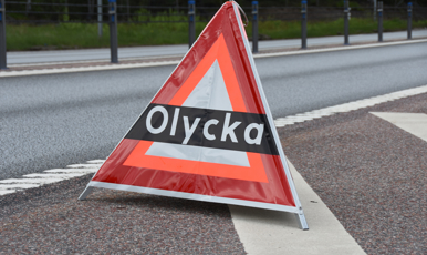 Varningstriangel med texten olycka placerad vid vägkant.