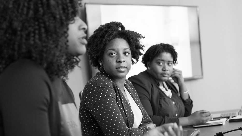 Tre kvinnor diskuterar på ett möte