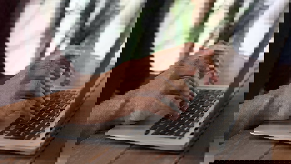 Fingrar skriver på en laptop