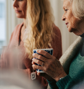 Två kvinnor samtalar och dricker te.