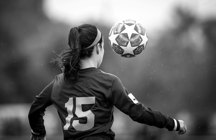 En kvinnlig fotbollsspelare och en boll dekorerad med stjärnor