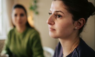 Allvarlig kvinna och en annan kvinna i bakgrunden.