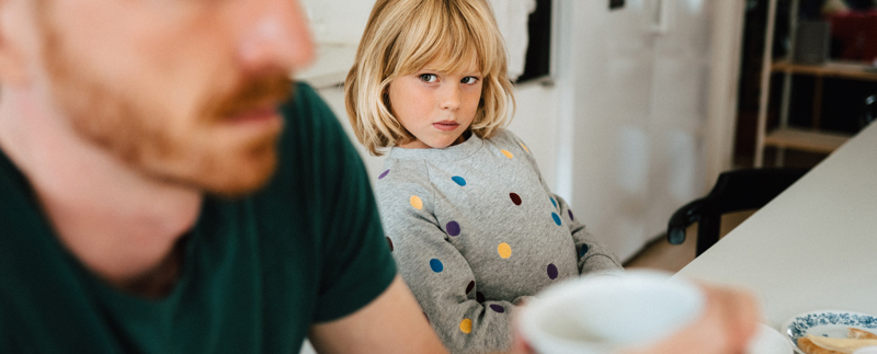 Barn tittar orolig på pappa som ser arg ut.