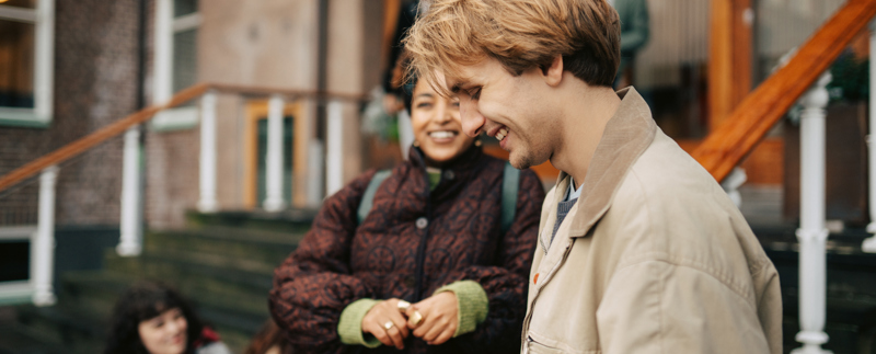 Glada ungdomar utanför en skola.