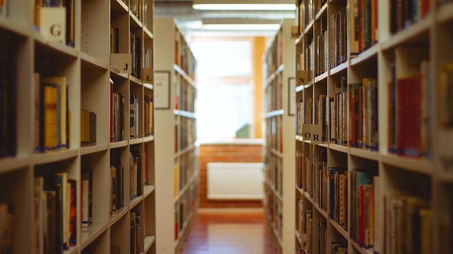 Böcker i alfabetisk ordning i ett bibliotek.