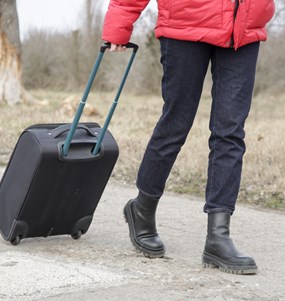 Ukrainsk kvinna på flykt med en resväska i handen.