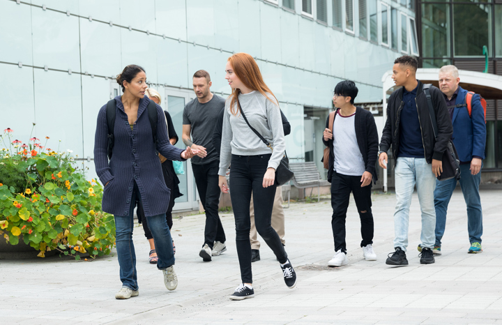 Studenter går och pratar utanför universitet.