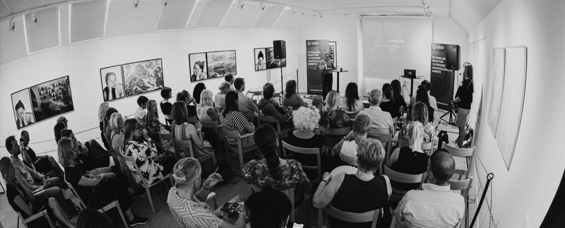 Ett rum med många åhörare som lyssnar till generalsekreterare Lena Ag som håller en presentation