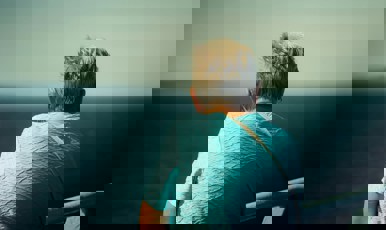 Pensionär tittar bort mot horistont.