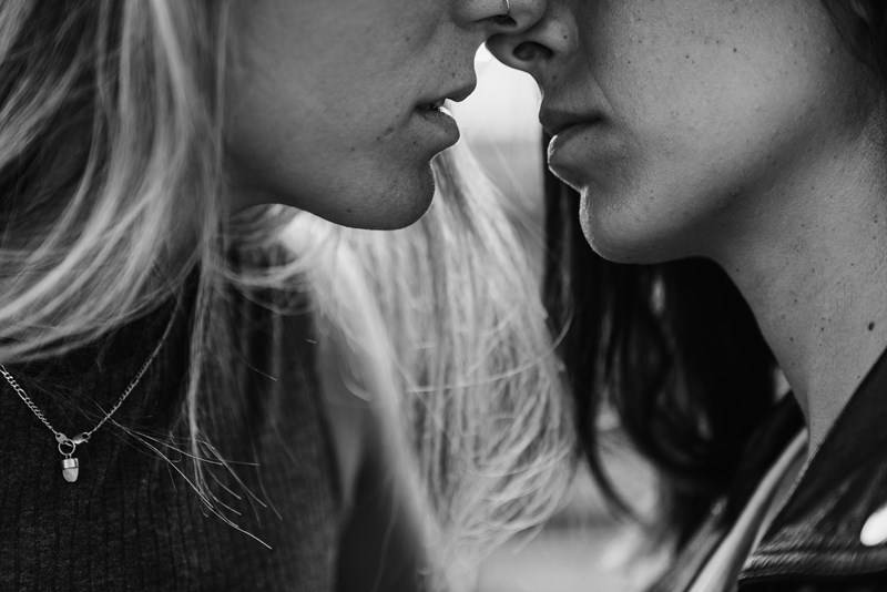 Två kvinnor på väg att kyssa varandra