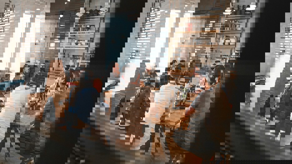 En grupp unga personer samtalar runt ett bord