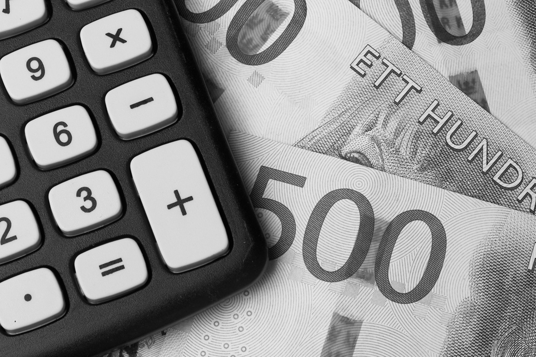 En miniräknare i närbild som ligger ovan på en bunt svenska sedlar