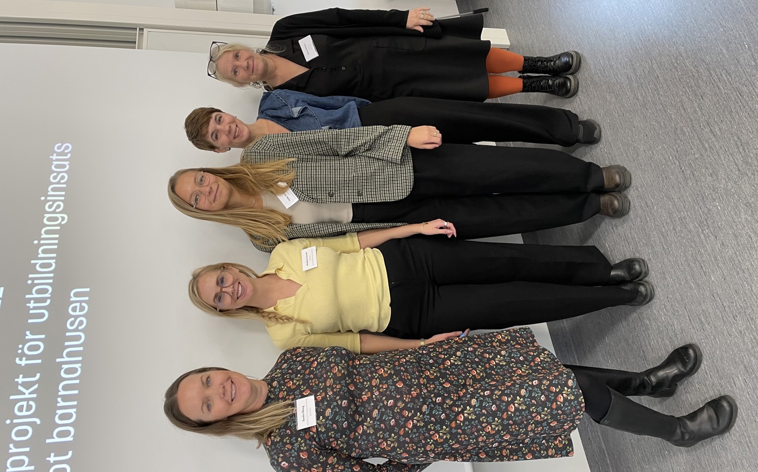 Fem kvinnor står uppställda framför en presentationbild om en utbildningsinsats