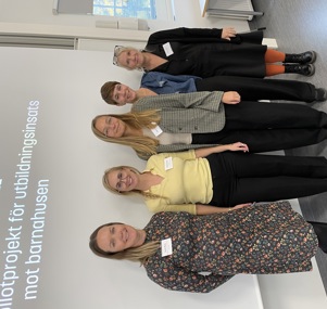 Fem kvinnor står uppställda framför en presentationbild om en utbildningsinsats