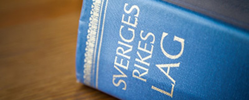 Sveriges Rikes Lagboken liggandes på ett bord med titeln i närbild